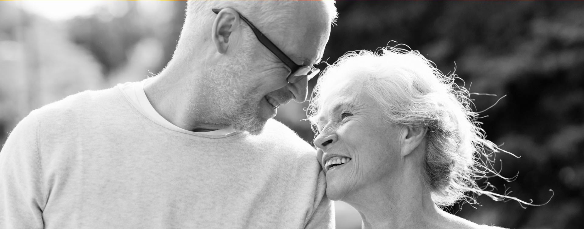 Implantologia: coppia di signori sorridenti in bianco e nero